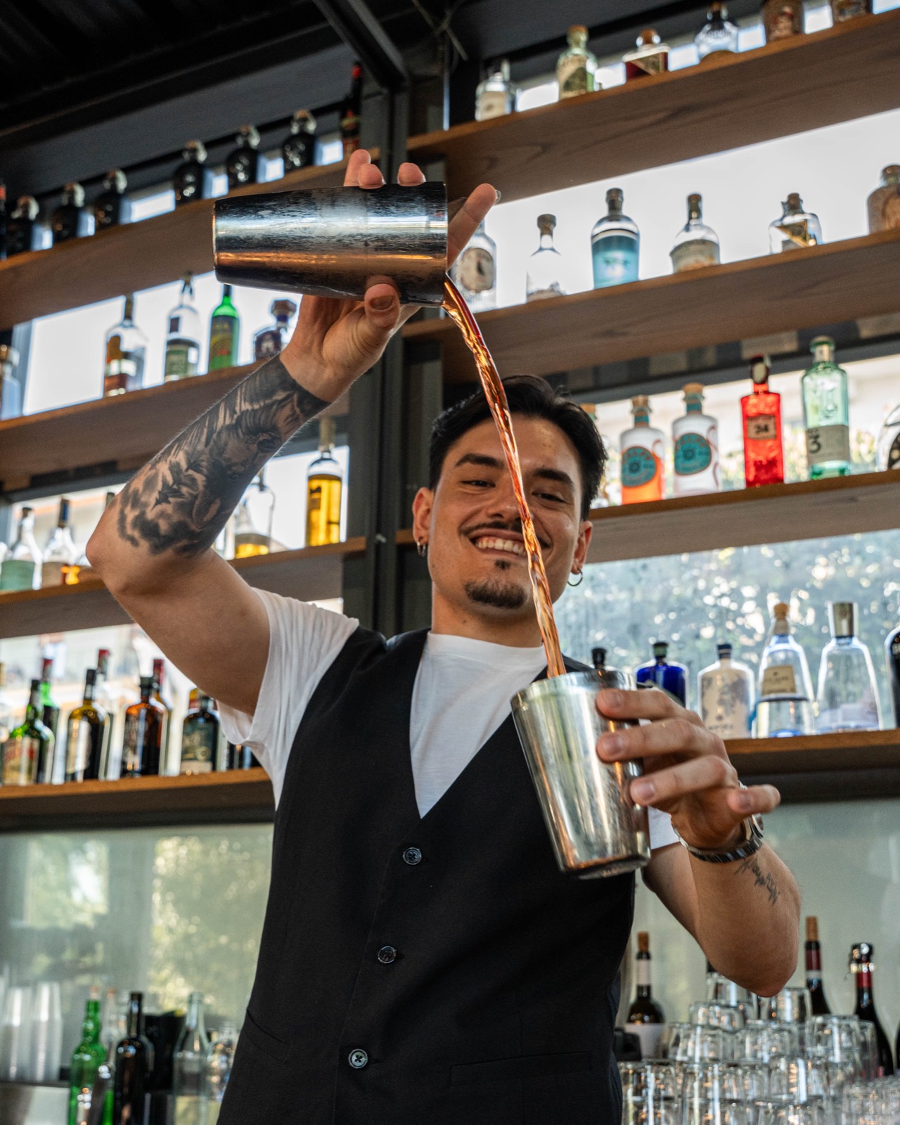 Barman che versa un cocktail al bancone del MABE